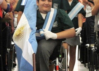 Un gesto de inclusión: un niño con parálisis cerebral participa en el arriado de la bandera
