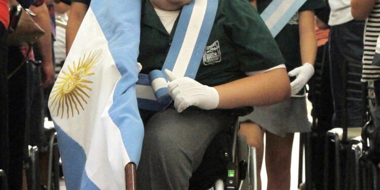 Un gesto de inclusión: un niño con parálisis cerebral participa en el arriado de la bandera